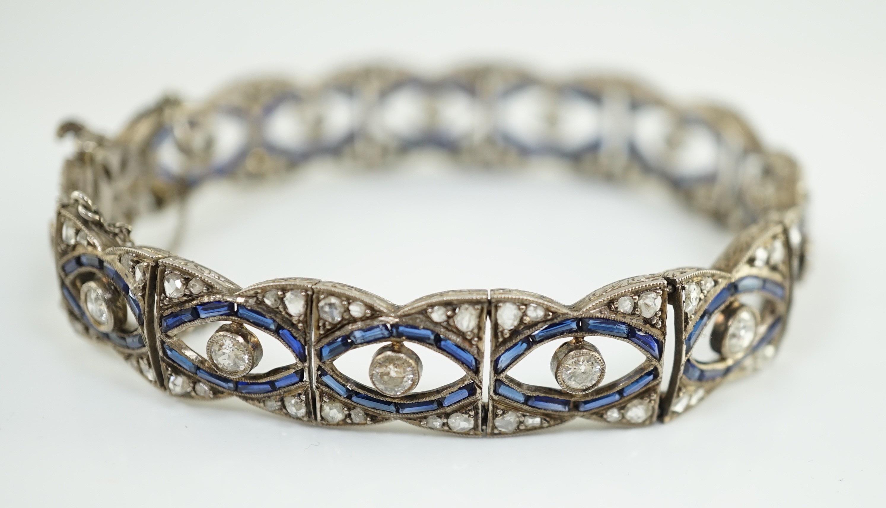 A 1920's 18ct white gold and millegrain set synthetic? sapphire and round and rose cut diamond set bracelet, with safety chain